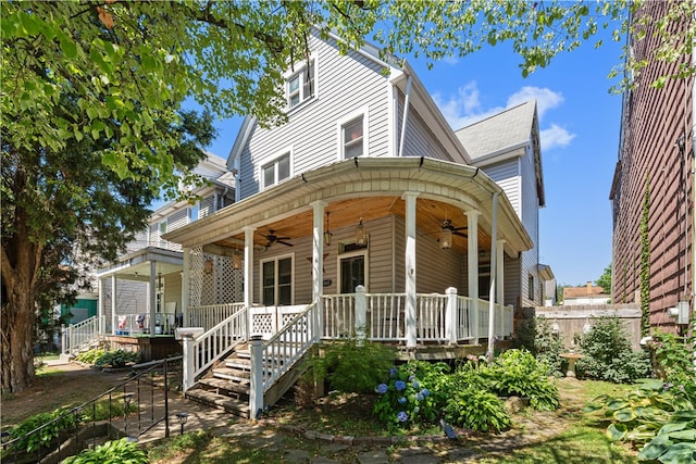 view of front of house featuring covered porch, ceiling fan, and stairway