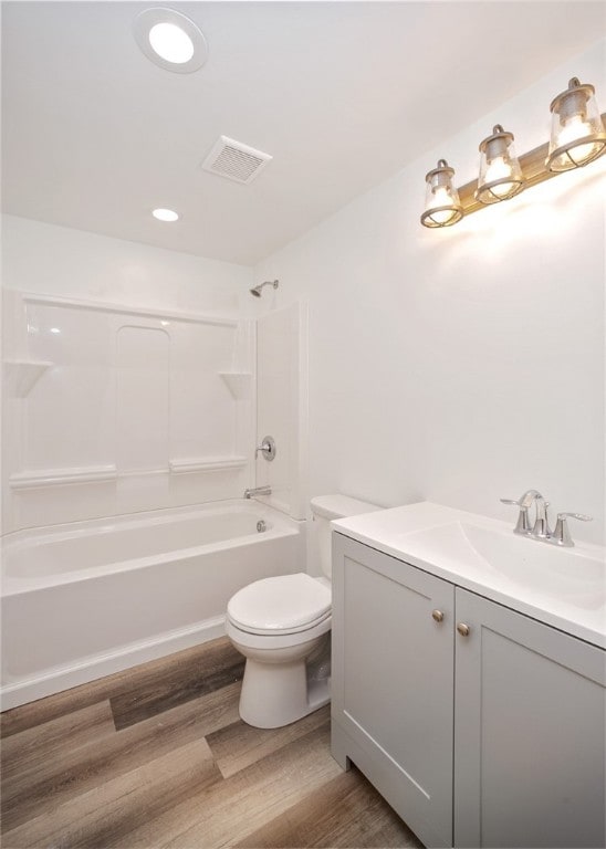 full bathroom with shower / tub combination, vanity, hardwood / wood-style floors, and toilet