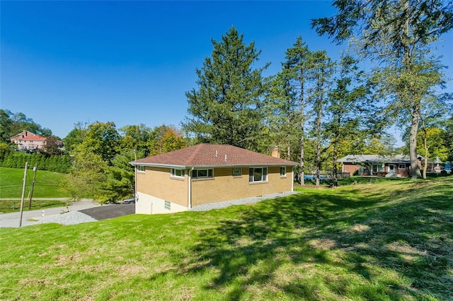 view of side of home with a yard