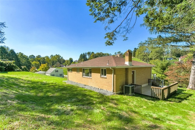 view of side of property featuring cooling unit and a yard