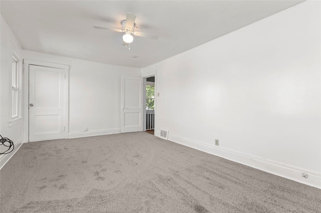 carpeted spare room with ceiling fan