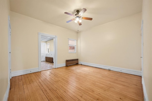 unfurnished bedroom with radiator heating unit, ceiling fan, and light hardwood / wood-style floors