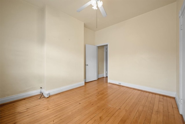 spare room featuring light wood-type flooring, ceiling fan, and high vaulted ceiling