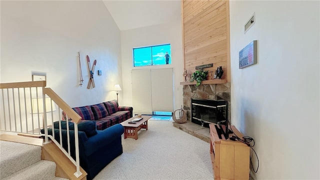 living room with high vaulted ceiling, a stone fireplace, carpet floors, and wooden walls