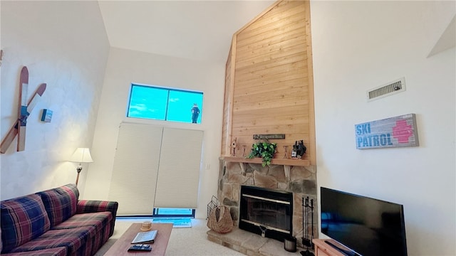 living room featuring carpet floors, high vaulted ceiling, wooden walls, and a stone fireplace