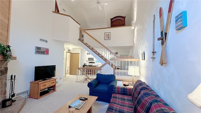 carpeted living room featuring ceiling fan and high vaulted ceiling