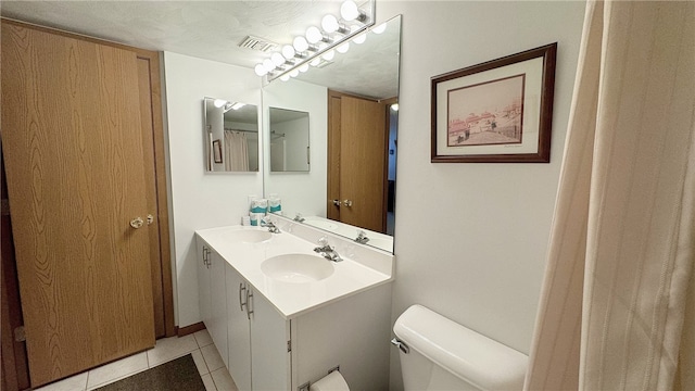 bathroom with vanity, toilet, and tile patterned floors