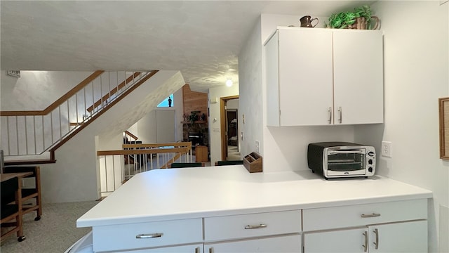 kitchen with white cabinets and carpet floors