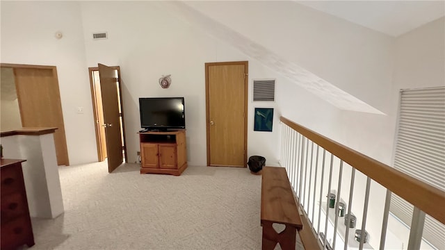 carpeted living room featuring high vaulted ceiling