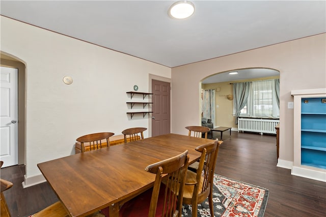 dining space featuring radiator heating unit and dark hardwood / wood-style floors