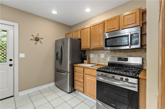 kitchen with light tile patterned flooring, stainless steel appliances, and tasteful backsplash