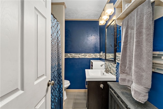 bathroom with tile patterned flooring, a textured ceiling, vanity, and toilet