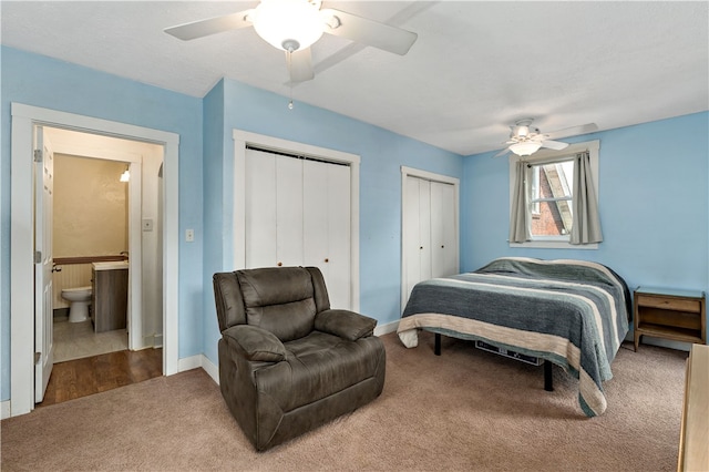 bedroom with carpet, ceiling fan, and multiple closets