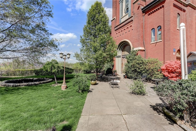 view of property's community featuring a patio area and a lawn