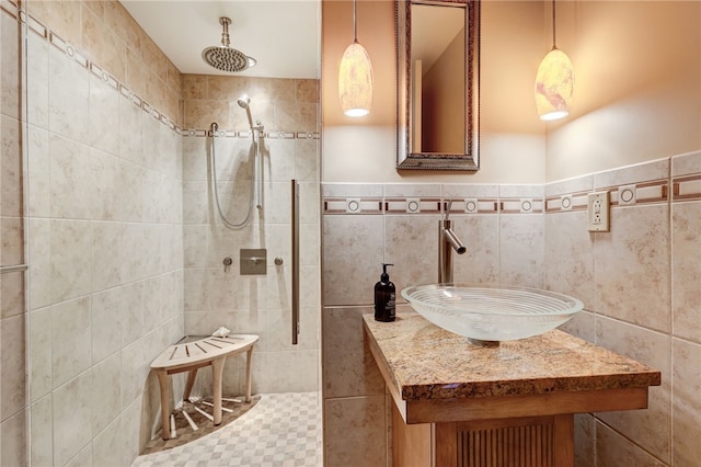 bathroom with sink, tile walls, and a tile shower