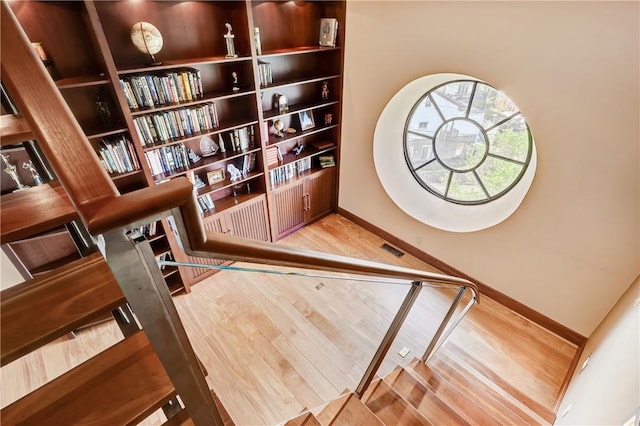 staircase with hardwood / wood-style floors