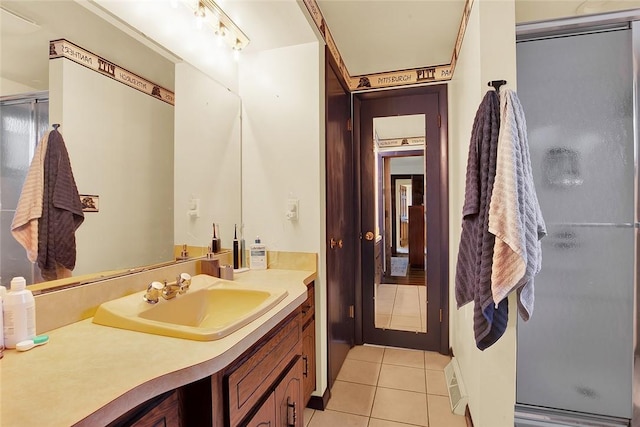 bathroom with tile patterned flooring, vanity, and a shower with door