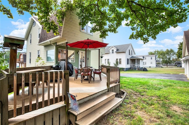 wooden deck featuring area for grilling and a yard