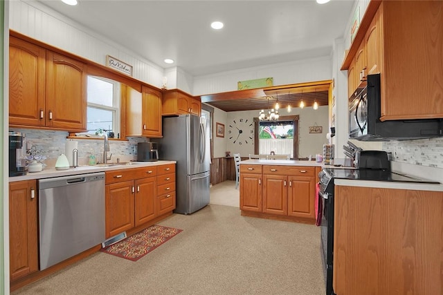 kitchen featuring an inviting chandelier, hanging light fixtures, decorative backsplash, appliances with stainless steel finishes, and kitchen peninsula