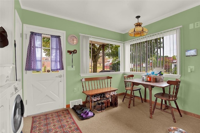 sunroom / solarium featuring a healthy amount of sunlight and stacked washer / drying machine