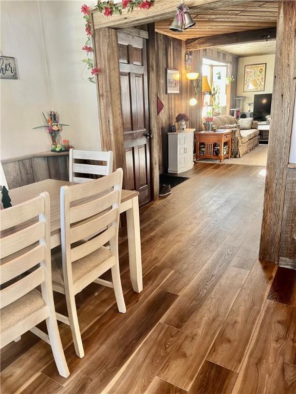 dining area with wood-type flooring and wooden walls