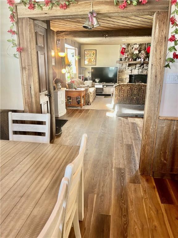 dining area with beam ceiling, wood-type flooring, and wooden ceiling