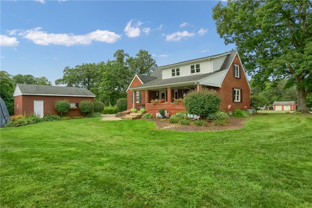 back of house featuring a yard and an outbuilding