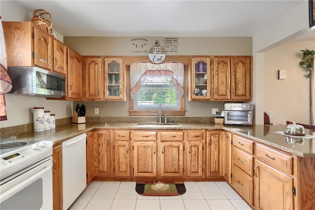 kitchen with kitchen peninsula, sink, white appliances, and light tile patterned flooring