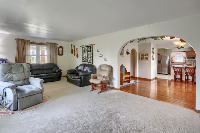 carpeted living room with an inviting chandelier