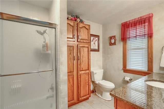 bathroom featuring vanity, toilet, walk in shower, and tile patterned floors