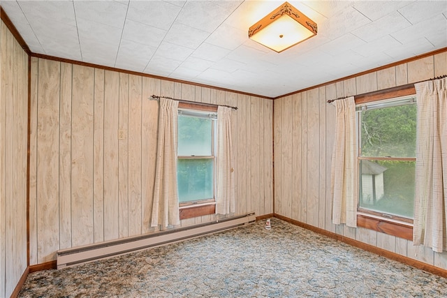 carpeted spare room featuring ornamental molding, a baseboard radiator, and wood walls