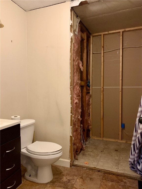 bathroom featuring tile patterned floors, a shower with shower curtain, toilet, and vanity