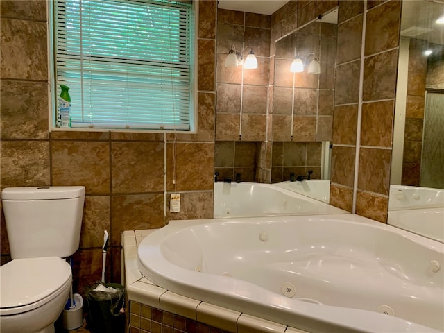 bathroom with tiled bath, toilet, and tile walls