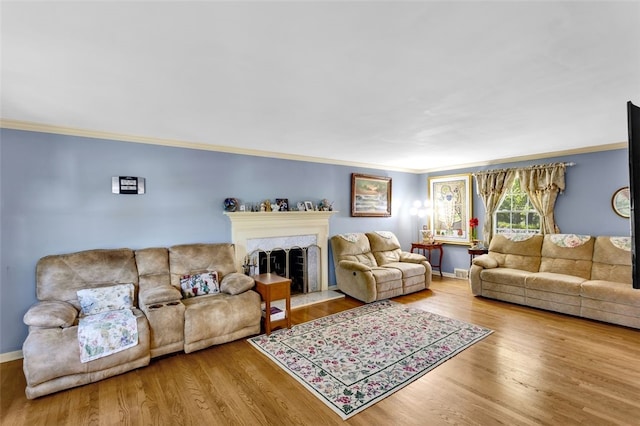 living room featuring hardwood / wood-style floors, a premium fireplace, and crown molding