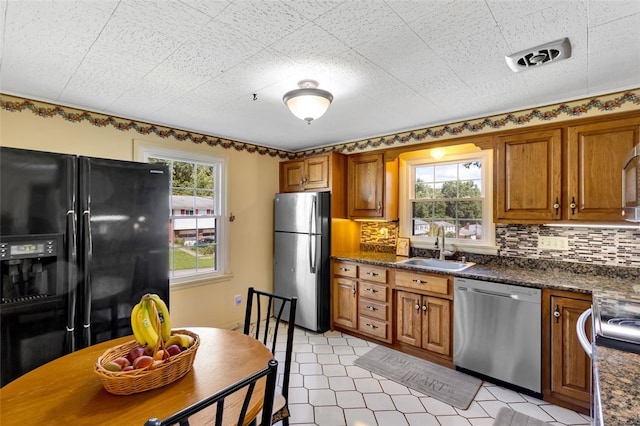 kitchen with dark stone countertops, sink, appliances with stainless steel finishes, and tasteful backsplash