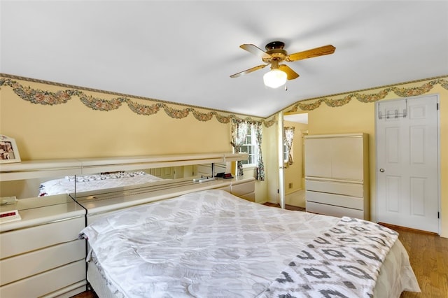 bedroom with ceiling fan, hardwood / wood-style floors, and lofted ceiling