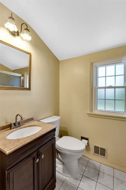 bathroom featuring tile patterned floors, vanity, lofted ceiling, and toilet