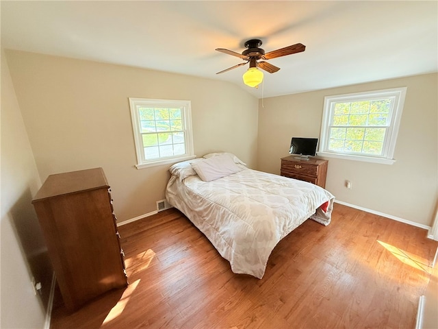 bedroom with light wood-type flooring, vaulted ceiling, and ceiling fan