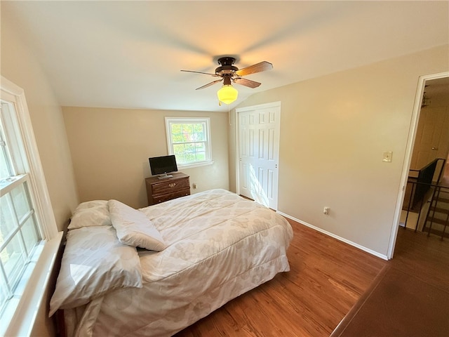 bedroom with a closet, hardwood / wood-style flooring, and ceiling fan