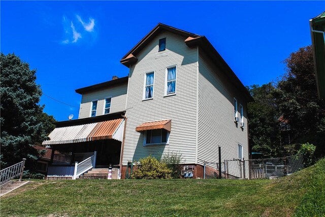 rear view of house featuring fence and a yard