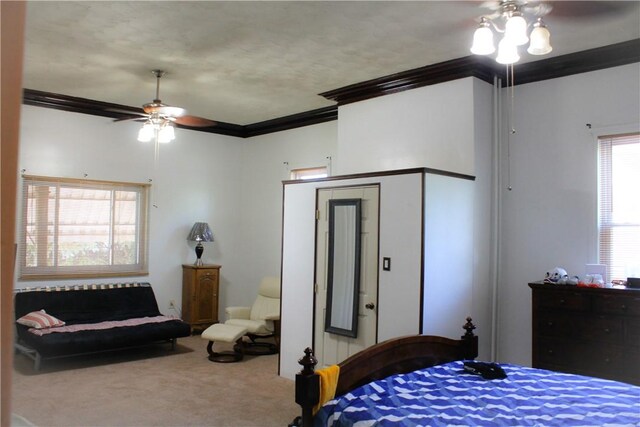 carpeted bedroom featuring crown molding and ceiling fan