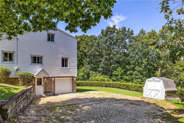 view of property exterior with a garage and a shed