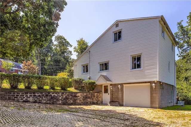 view of front of house with a garage and central air condition unit