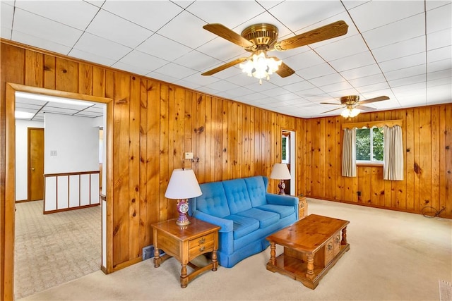 living area featuring wood walls and carpet flooring