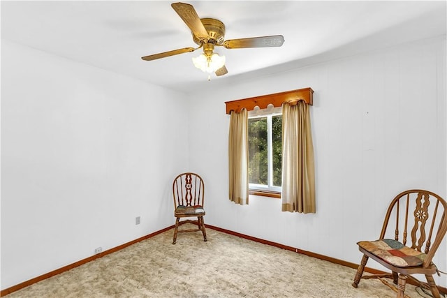 living area featuring carpet floors, ceiling fan, and baseboards