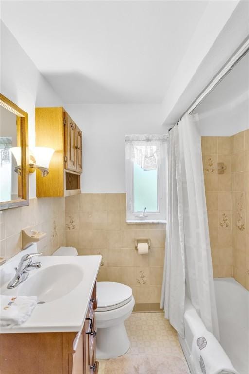 full bath featuring shower / bath combination with curtain, tile walls, toilet, and vanity