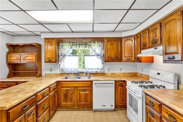 kitchen featuring under cabinet range hood, white appliances, a sink, wooden counters, and brown cabinets