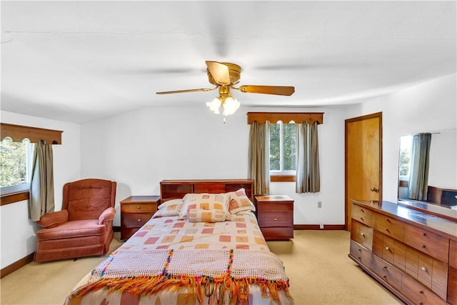 bedroom with ceiling fan, baseboards, vaulted ceiling, and light colored carpet