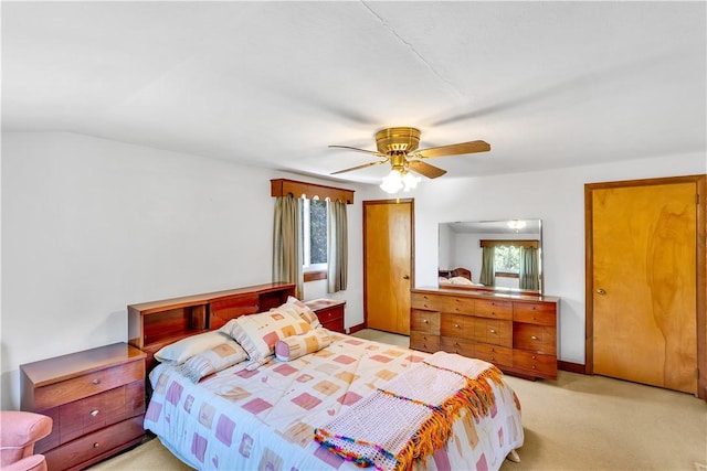 bedroom with multiple windows, a ceiling fan, and light colored carpet