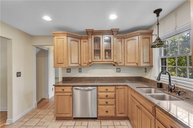 kitchen with light wood-type flooring, dishwasher, dark stone counters, and sink